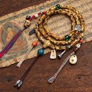 EverestArtstudios Carved Yak Bone 108-Bead Mala with Camel Bone, Glass and Agate Accents — styled on wood with a scripture display prop
