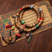 EverestArtstudios Camel Bone 108-Bead Mala with Carved Mahakala-Inspired Accent — styled on wood with a scripture display prop